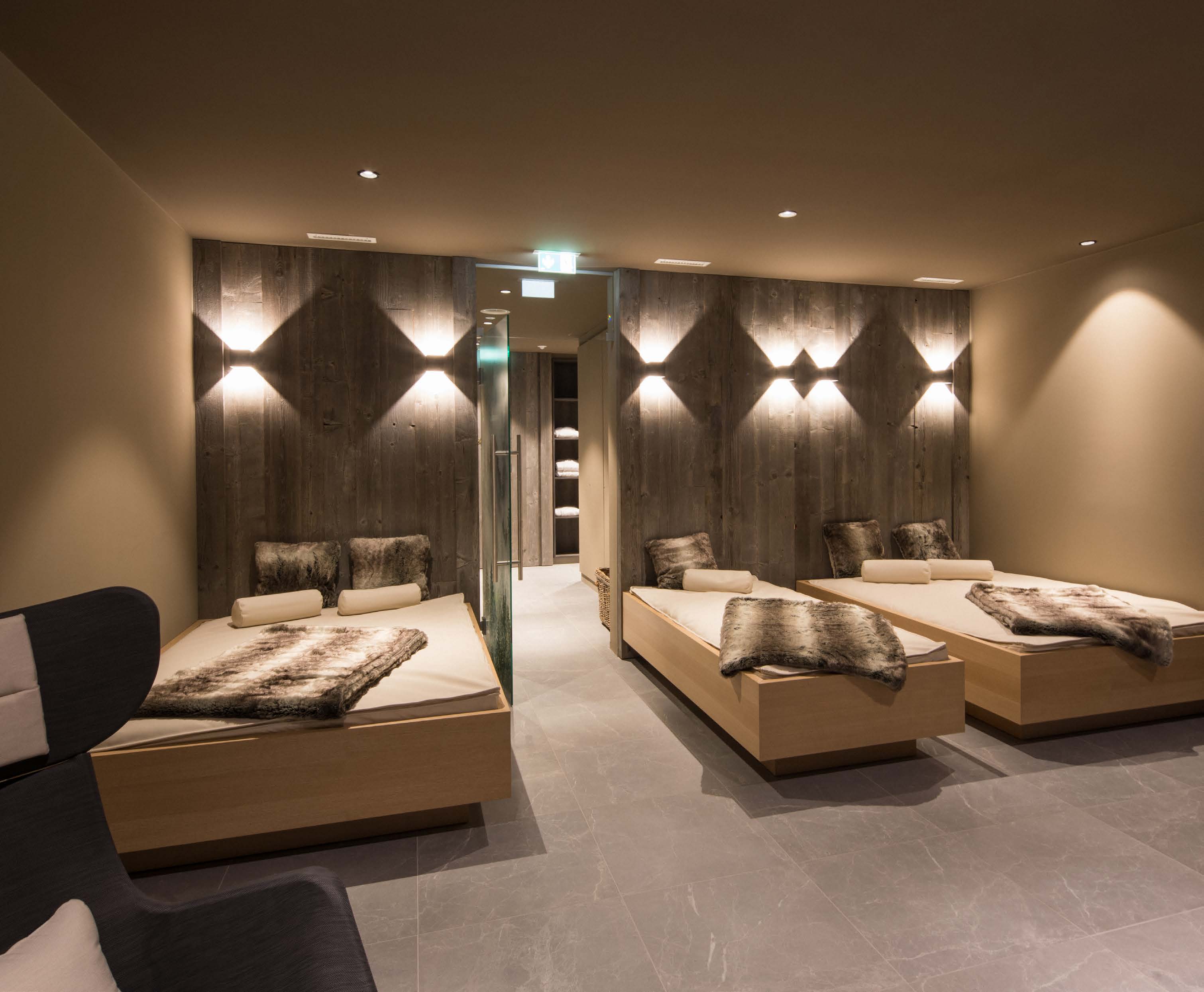 Relaxation room of the wellness area with water beds, fur blankets and a wooden light wall